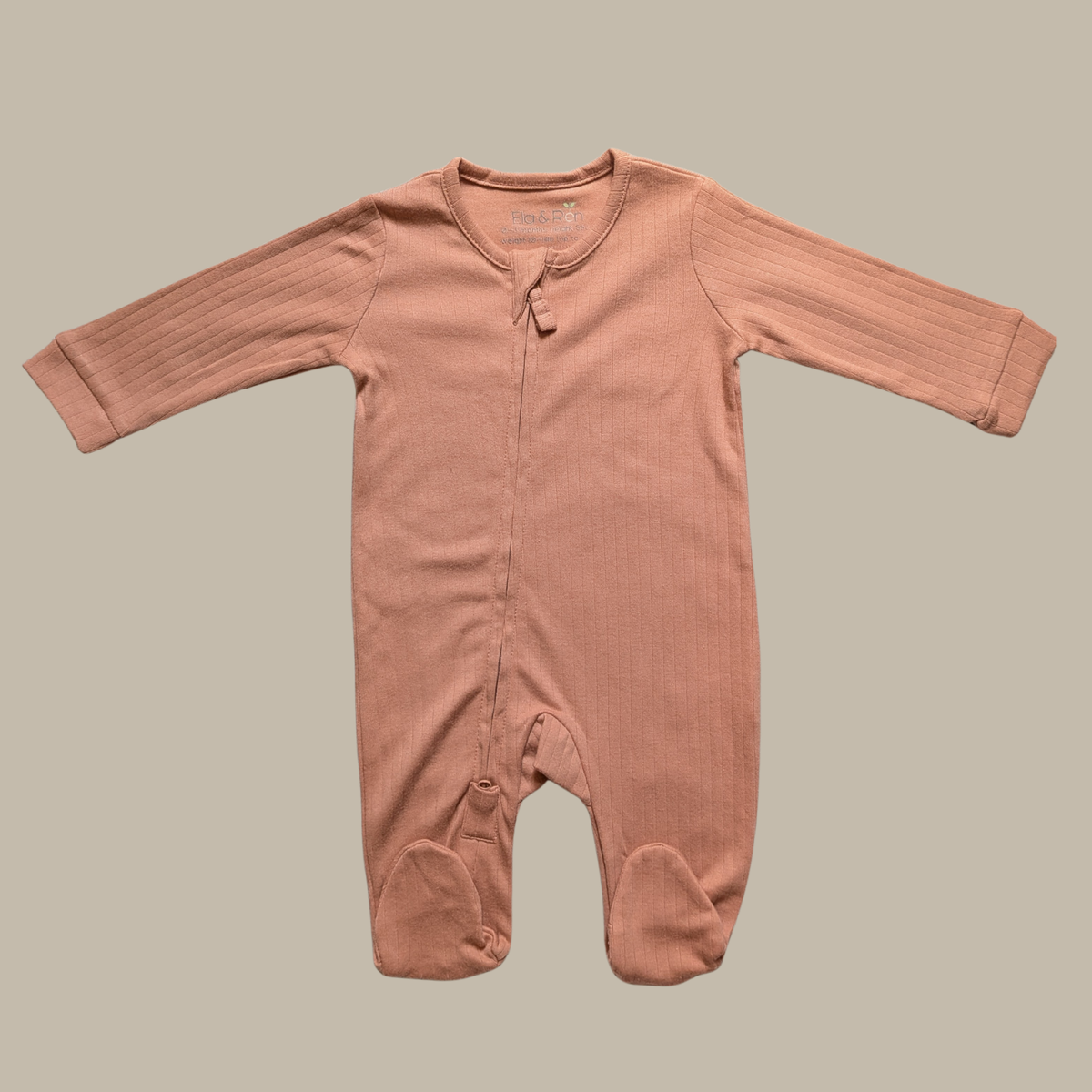 A long-sleeve baby footed sleeper in a dusty rose pink cotton