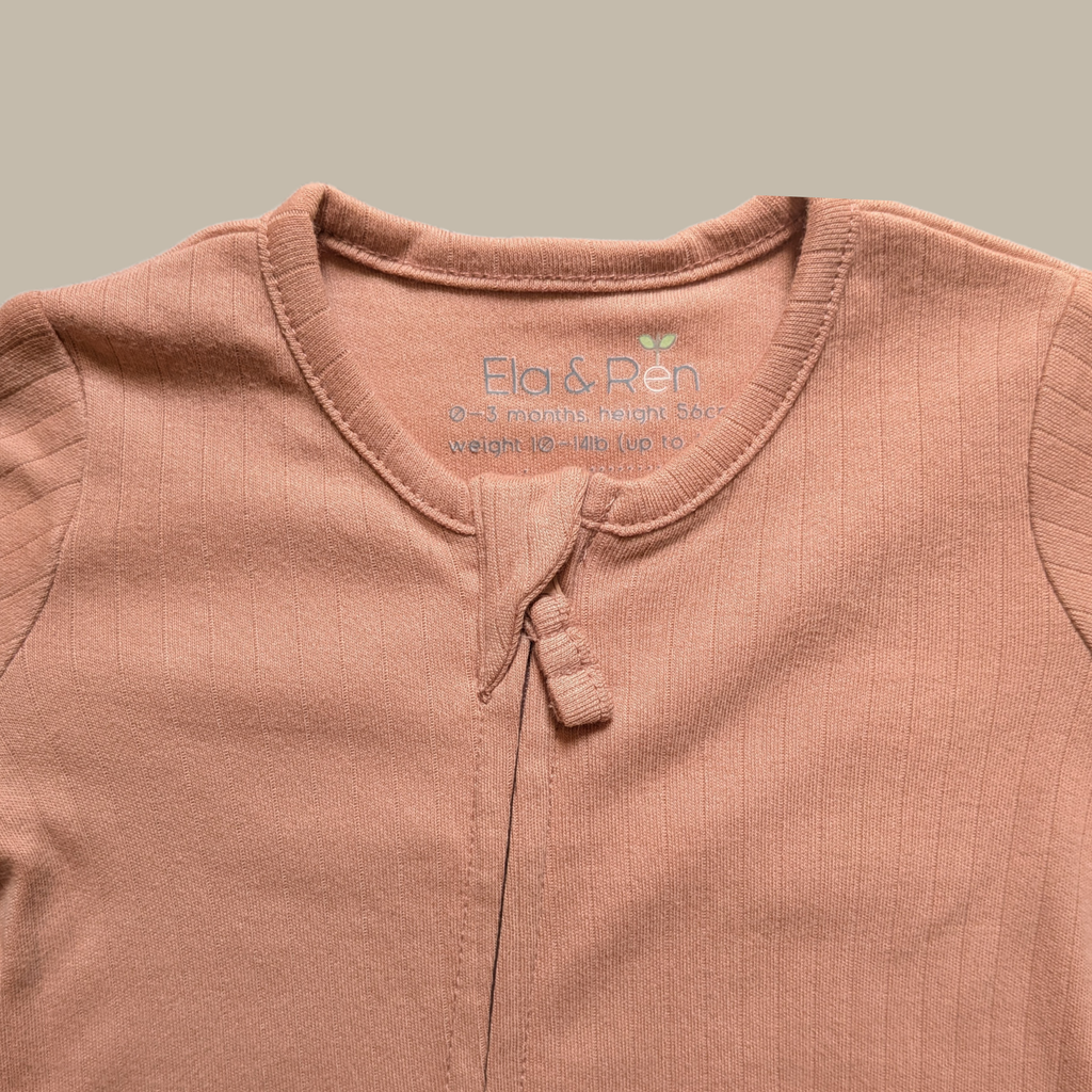 Close-up of a baby top in a dusty rose pink color, showing the inner neck label with the brand name 'Ela & Ren'.