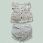Baby outfit set with top and shorts on a light green background