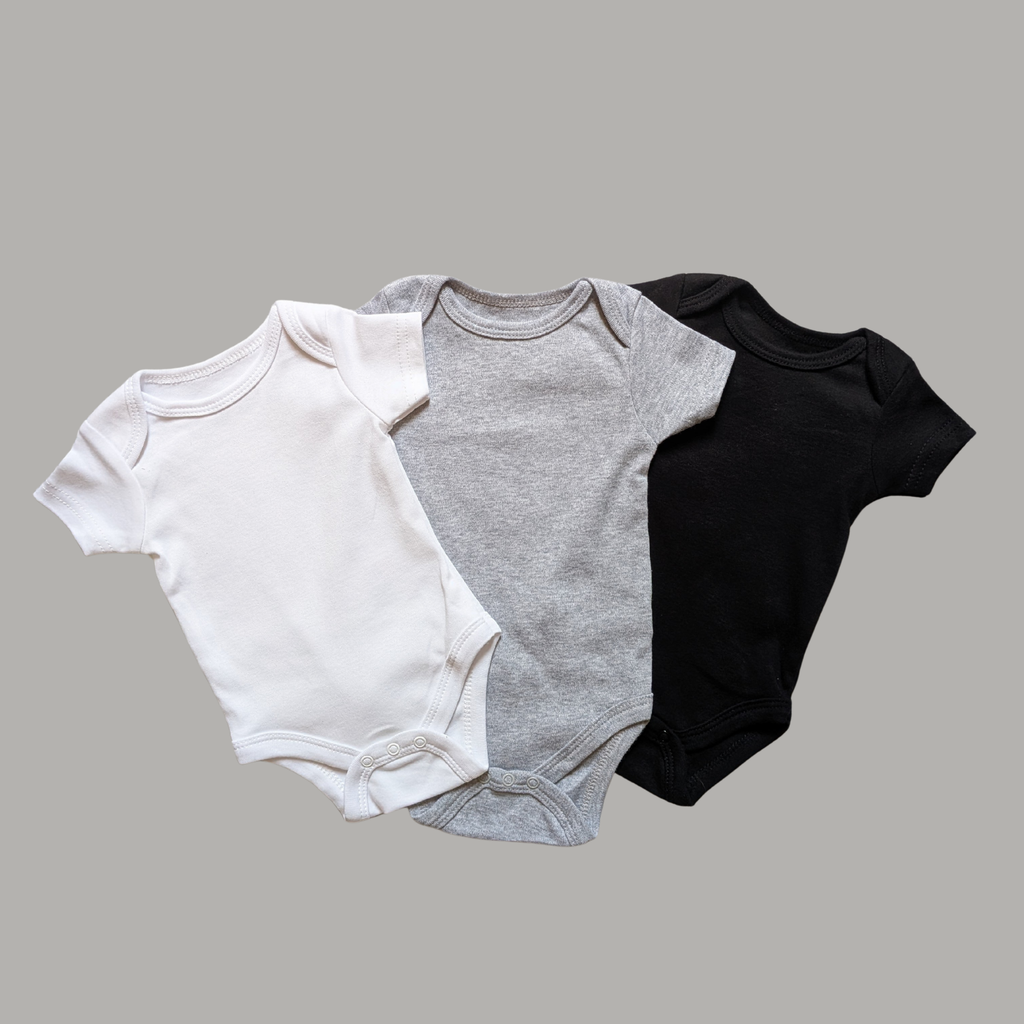 Three short-sleeve cotton baby bodysuits in white, heather gray, and black..