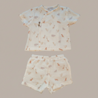 Children's outfit with patterned shirt and shorts on a beige background