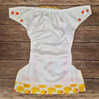 White diaper with yellow duck pattern on a wooden surface