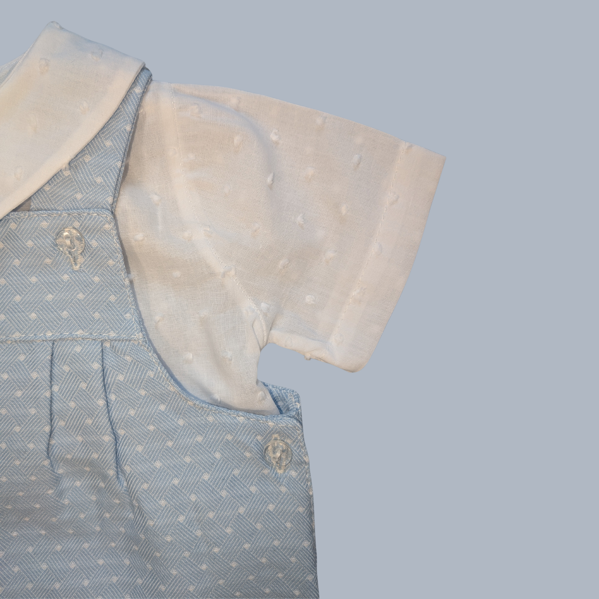 Light blue romper with white collar on a gray background