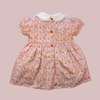 Floral dress with a white collar on a pink background