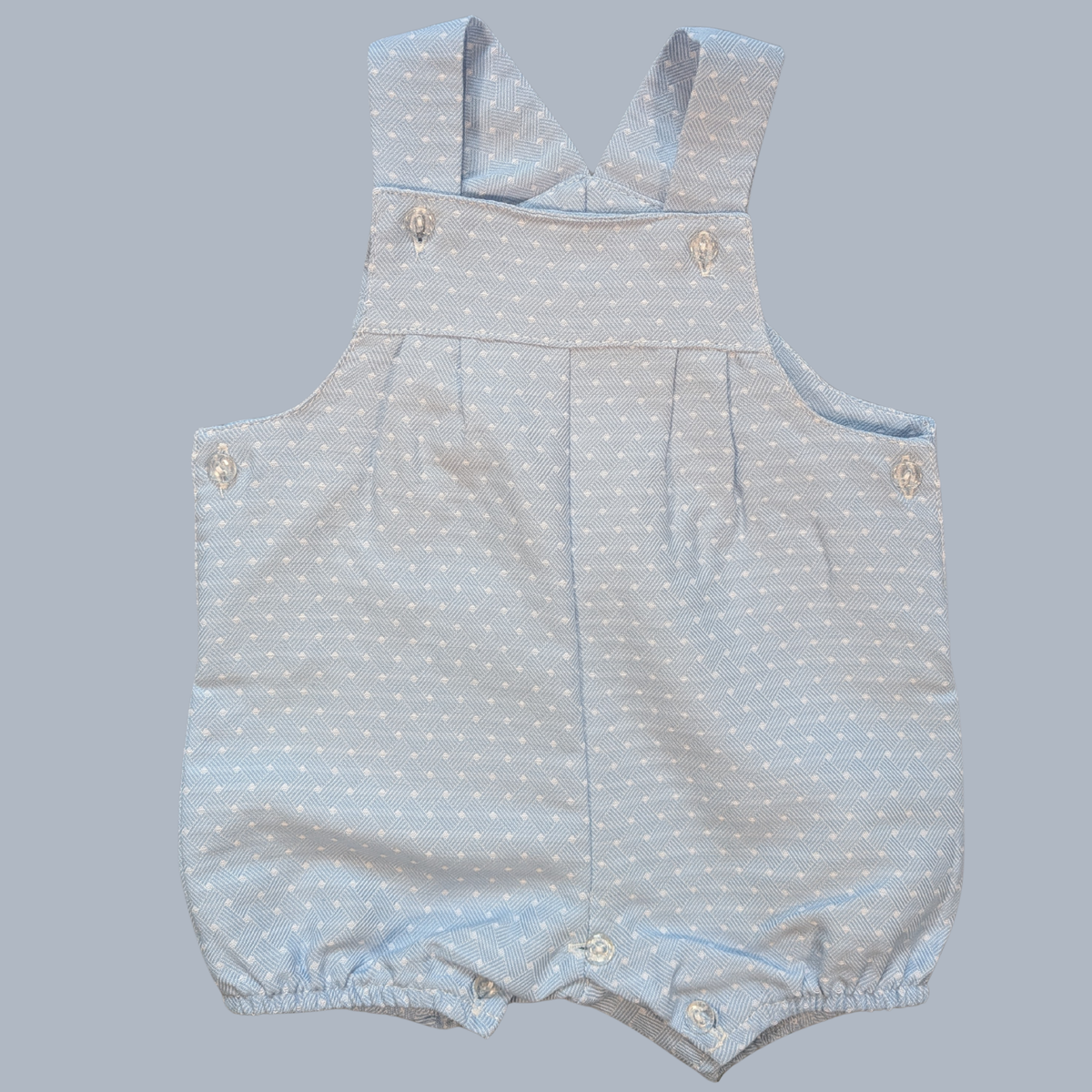 Baby romper with light blue polka dot pattern on a gray background