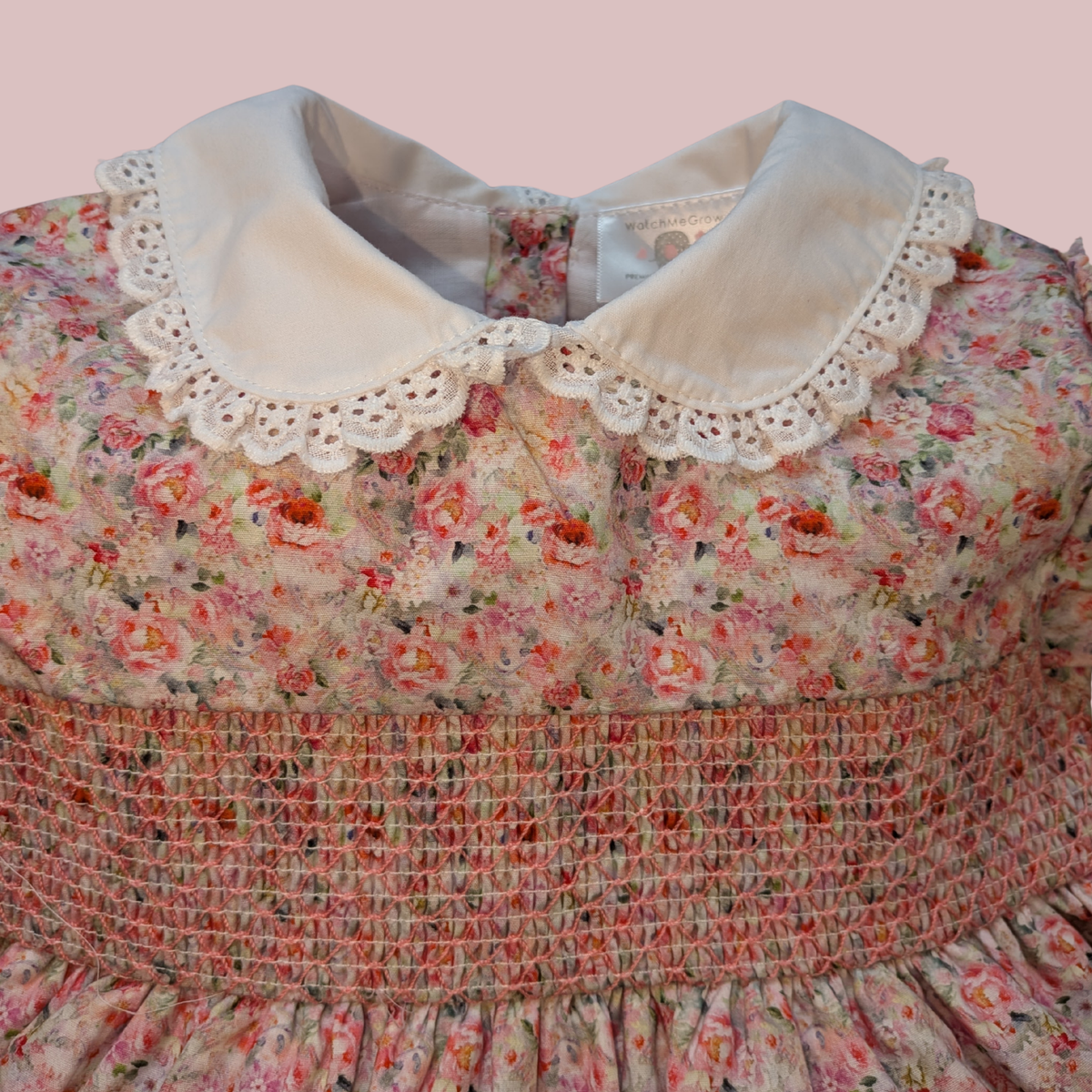 Floral dress with a white lace collar on a pink background