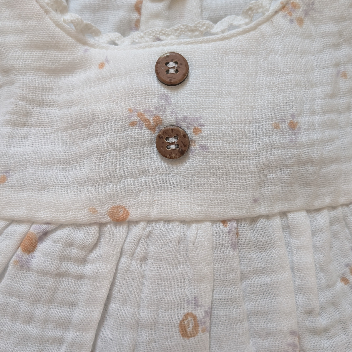 Close-up of a textured fabric with buttons and floral patterns