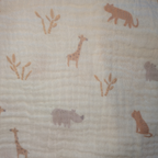 Textile with animal pattern including giraffes, rhinos, and other animals on a beige background