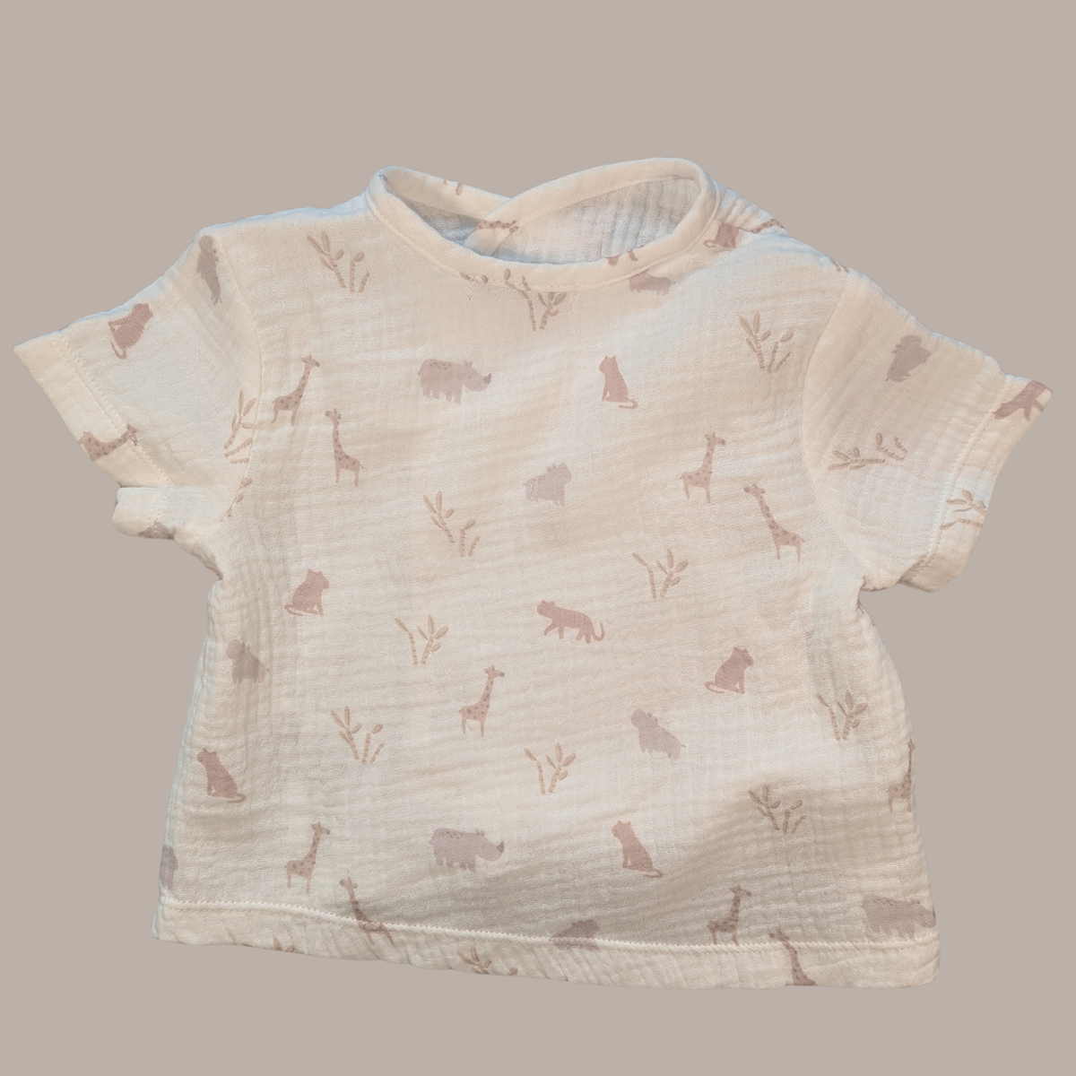 Baby t-shirt with animal pattern on a beige background