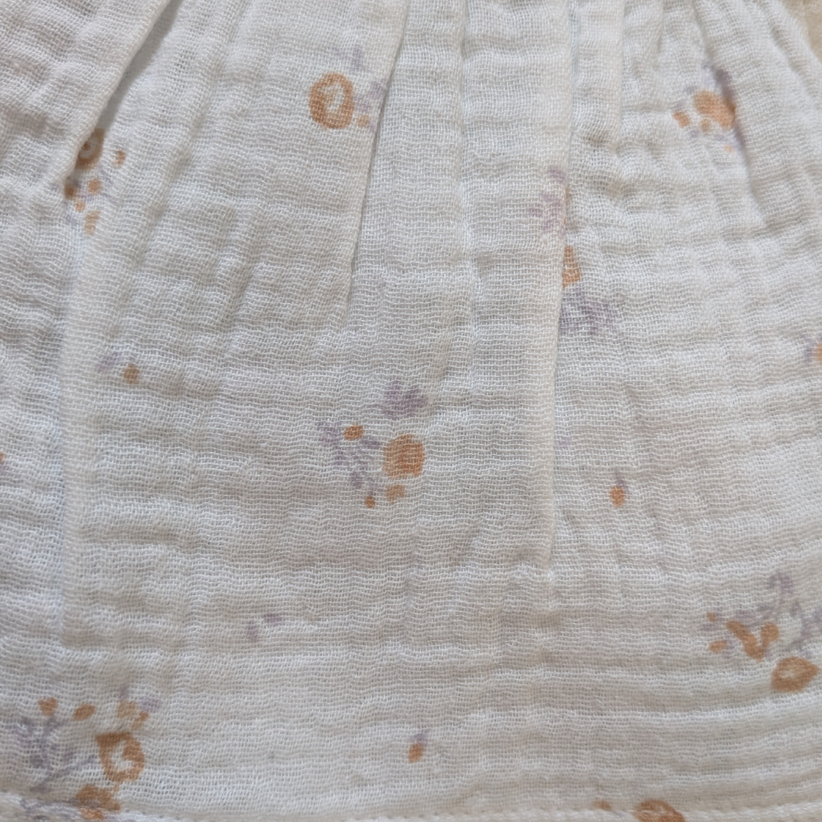 Close-up of a textured fabric with small floral patterns on a light background